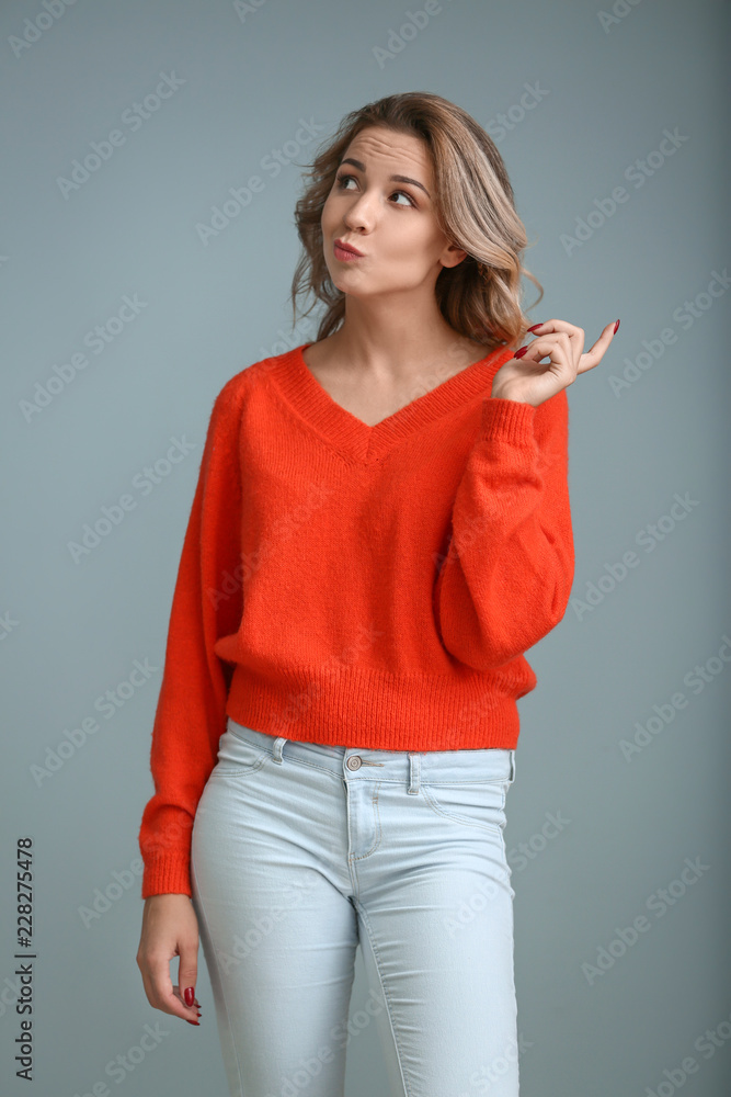 Portrait of thoughtful young woman on color background