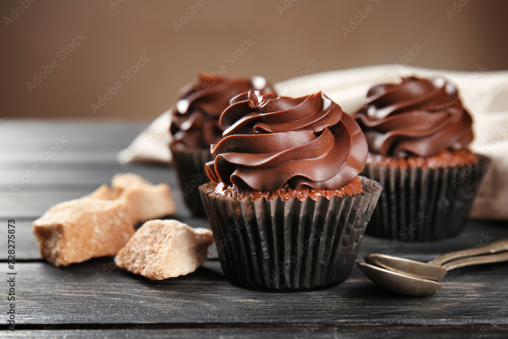 Delicious chocolate cupcakes on wooden table