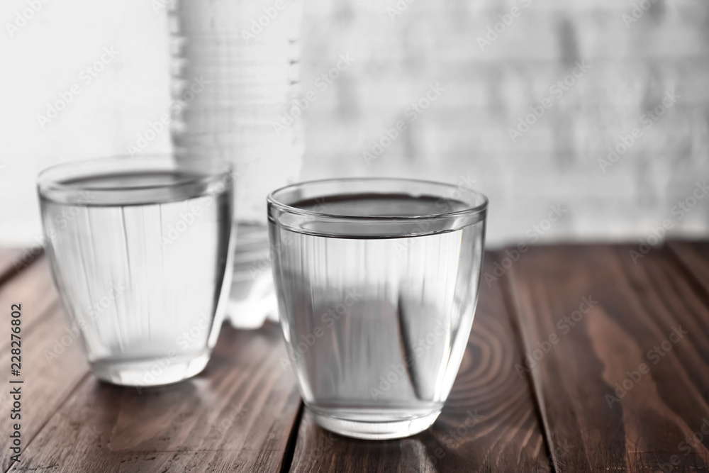 Glasses with fresh water on wooden table