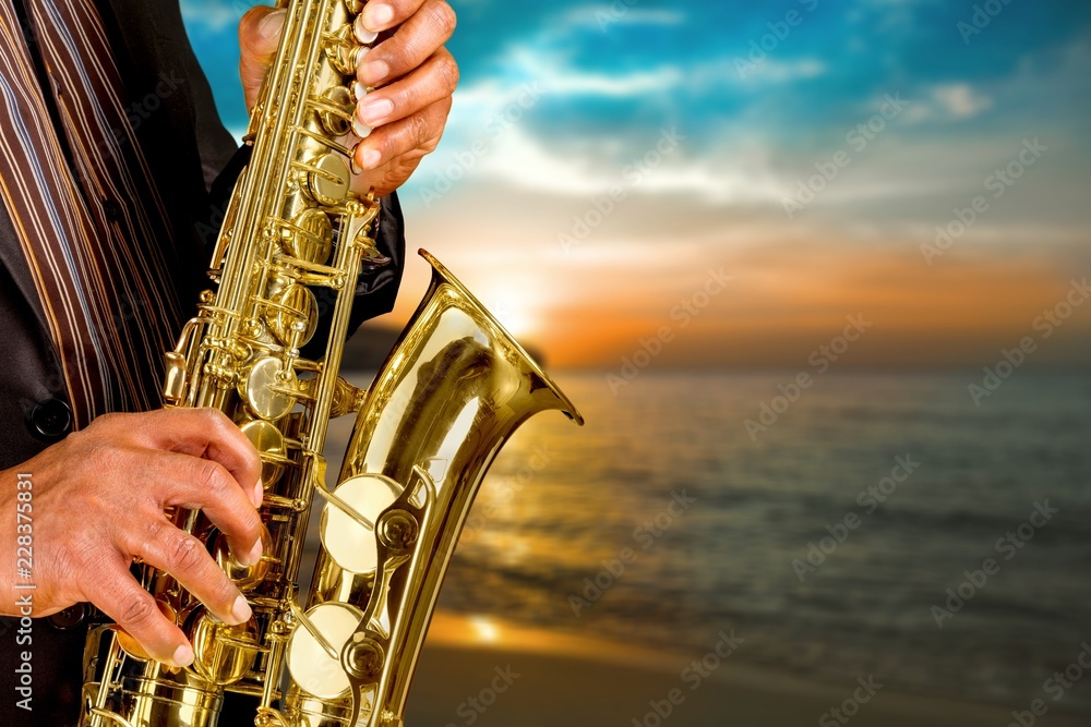 Close-up man playing on saxophone on blurred