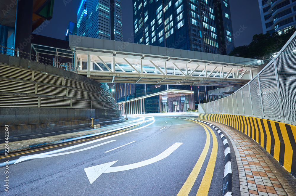 Empty asphalt city street road with walkway bridge and light trail , night scene