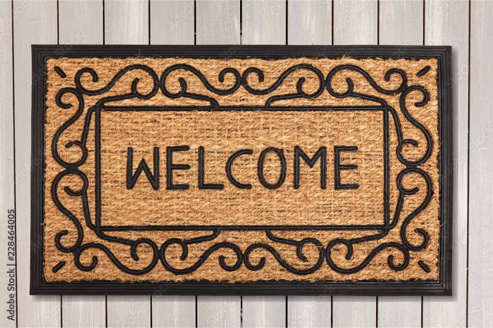 New welcome doormat on wooden floor