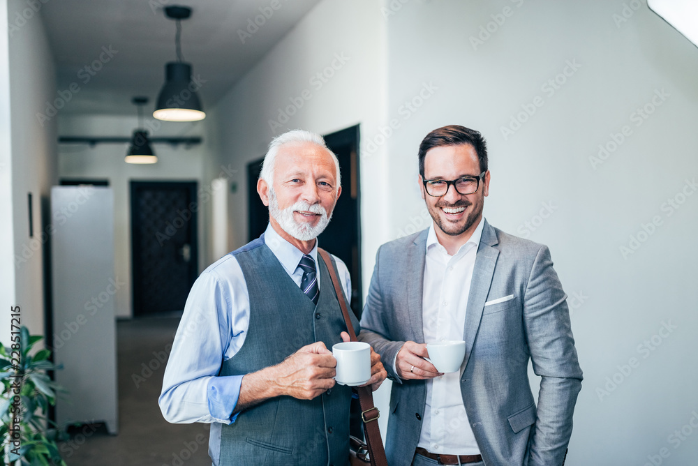 Senior businessman on a coffee break with younger colleague.