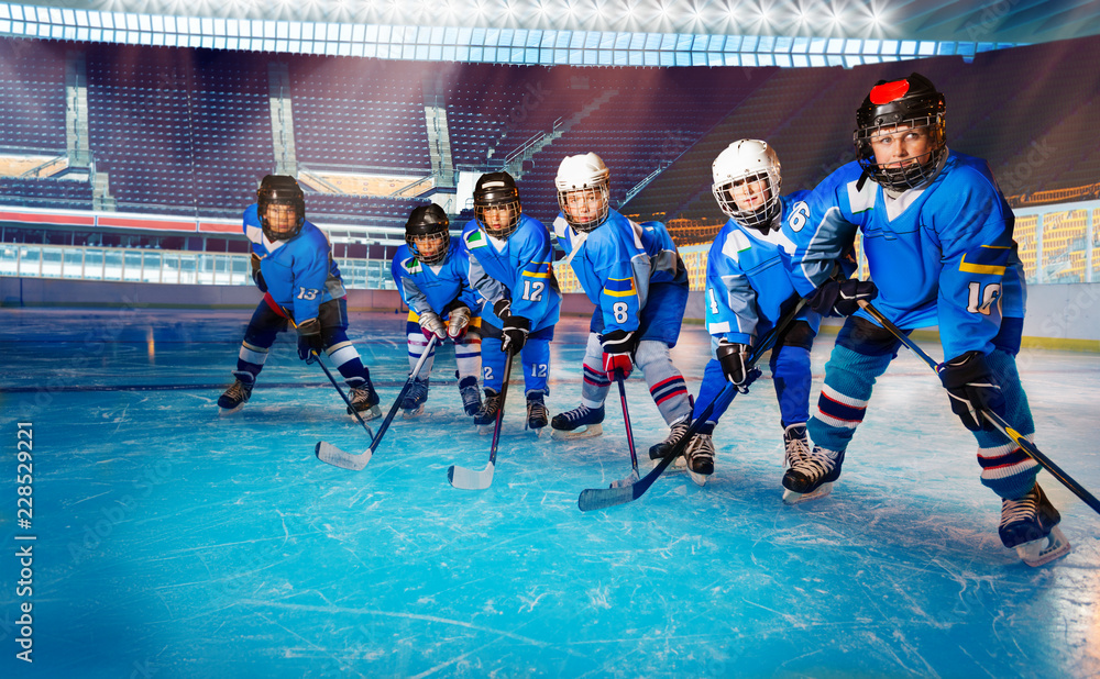 Young hockey players ready for puck on ice rink