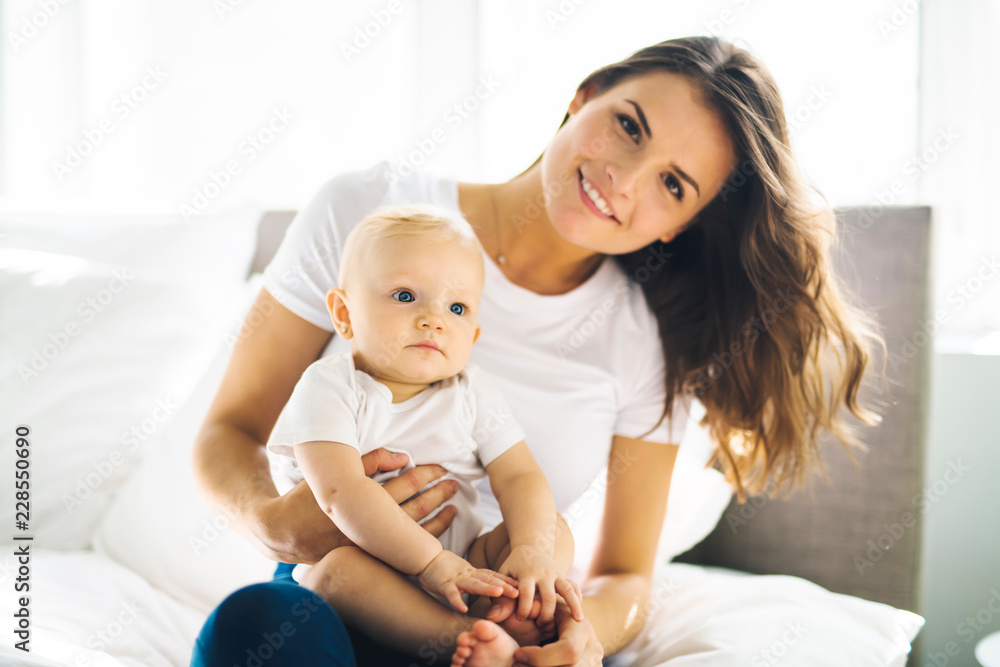 mother with baby on bed having good time