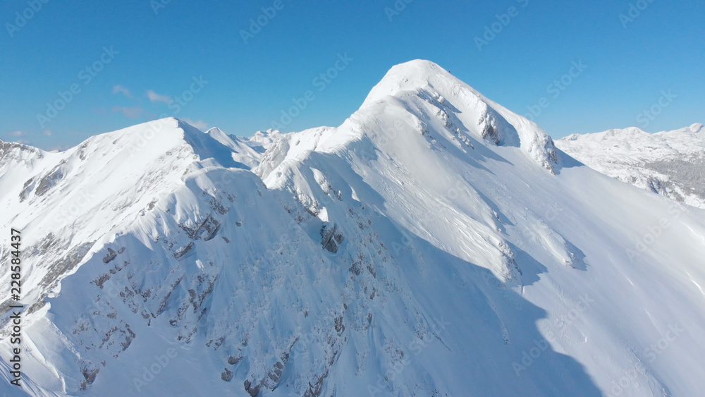 航空航天：拍摄阳光明媚的阿尔卑斯山上一座雄伟的雪山山脊。