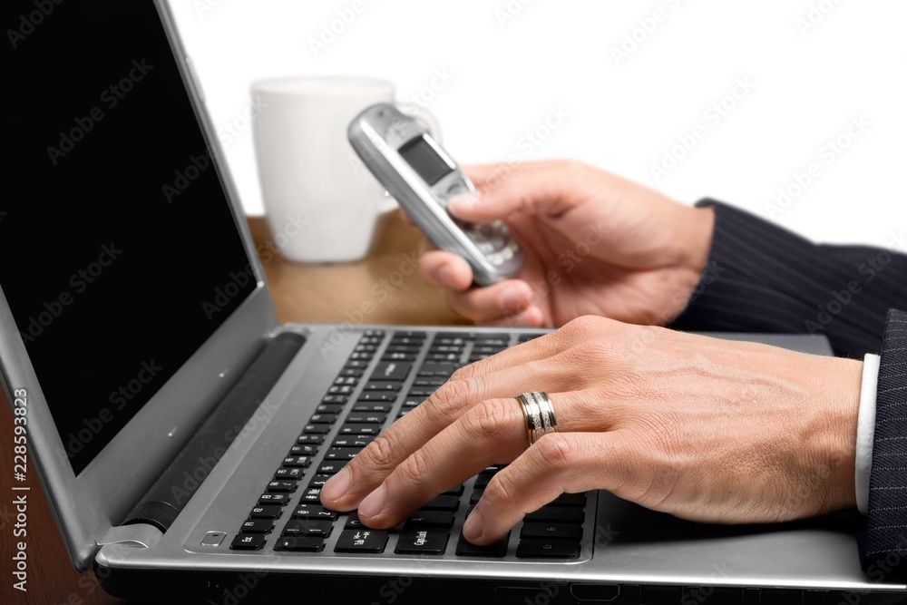 Portrait of man hands holding phone and using laptop isolated on