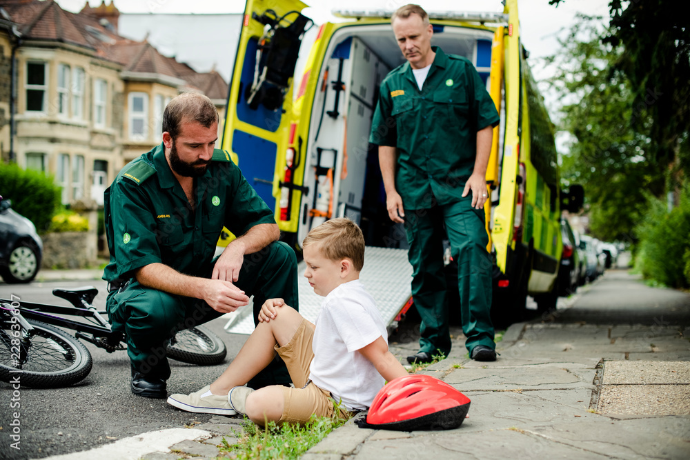 Injured boy getting help from paramedics