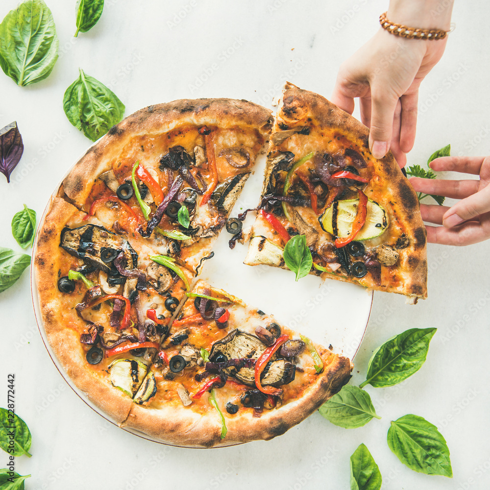 Summer dinner or lunch. Flat-lay of peoples hands taking freshly baked Italian vegetarian pizza wit