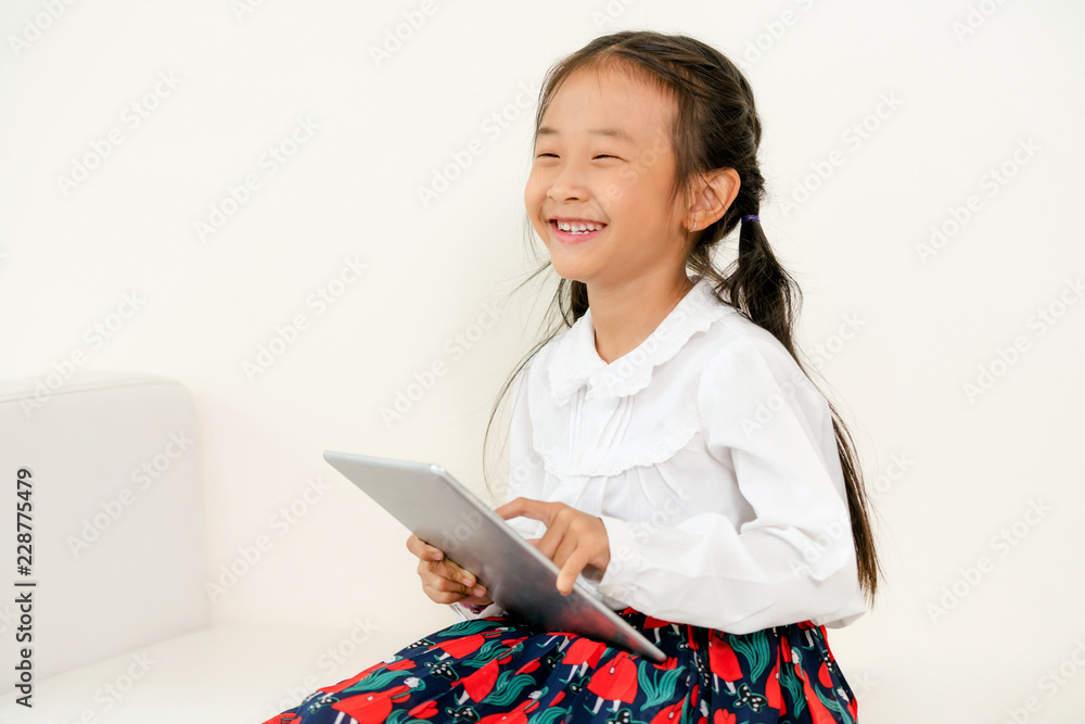 Little kid on white background with tablet.