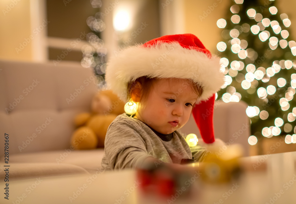 Toddler boy playing with a Santa hat around Christmas time