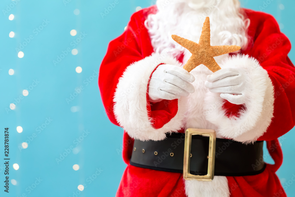 Santa holding a starfish on a shiny light blue background