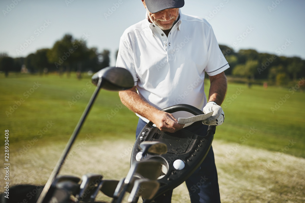 Senior man reading his scorecard during a golf game