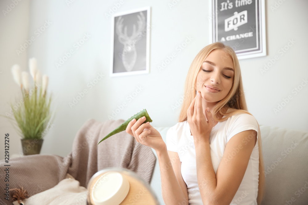 Beautiful young woman using aloe vera at home