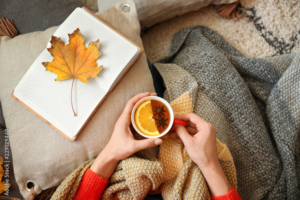 Young woman with cup of hot tea resting at home