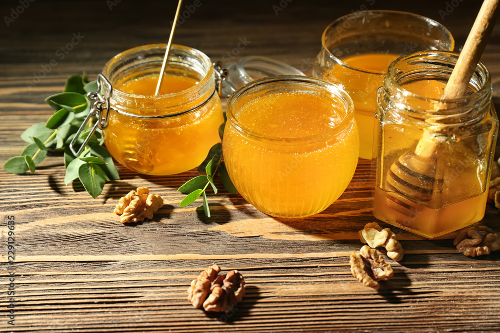 Jars of honey on wooden table