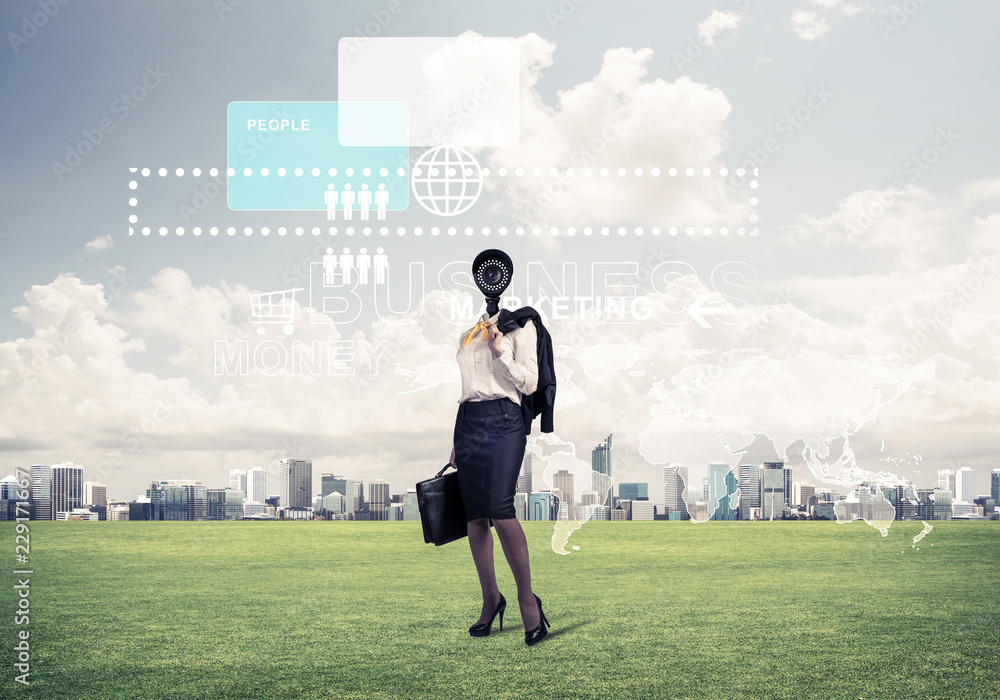 Camera headed woman standing on green grass against modern citys