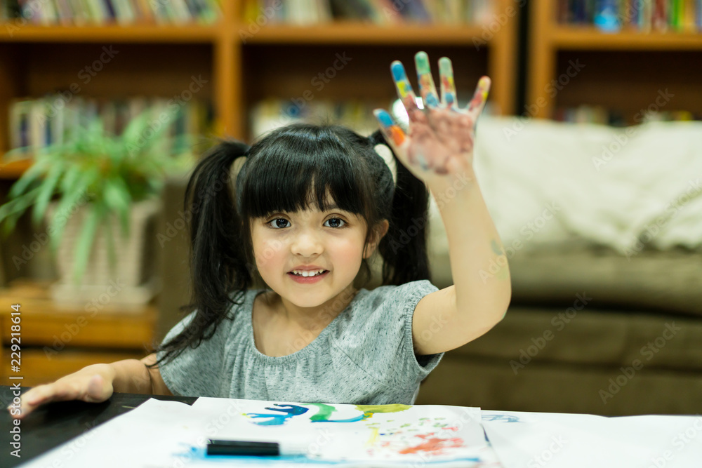 cheerful girl kid enjoy color painting with creativity ideas present and messy hand at home