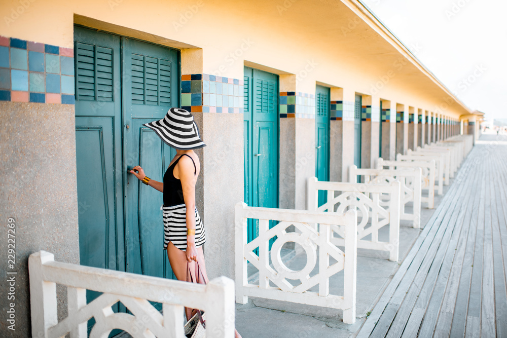 Beautiful woman near the old locker rooms on the beach in Deauville, famous french resort in Normand