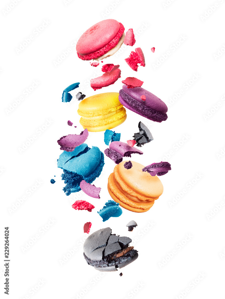 Сolored macaroons is torn to pieces in the air on a white background