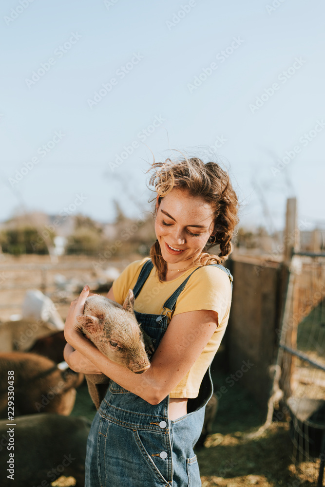 Young volunteer with a piglet, The Sanctuary at Soledad, Mojave