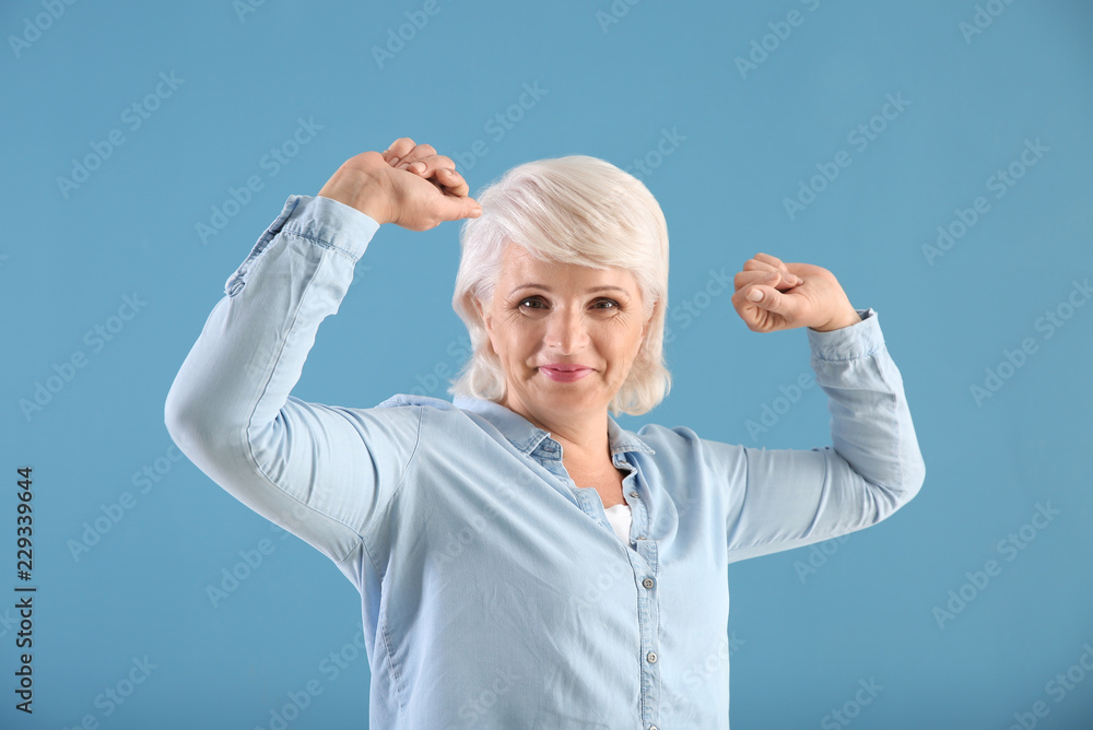 Portrait of successful mature woman on color background