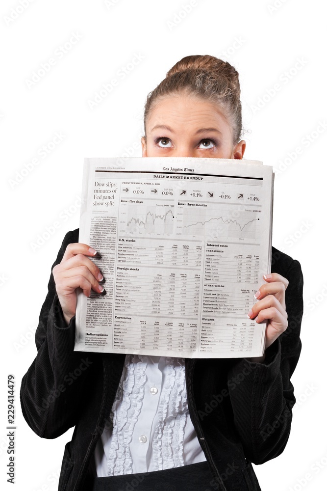 Beautiful young businesswoman reading business news