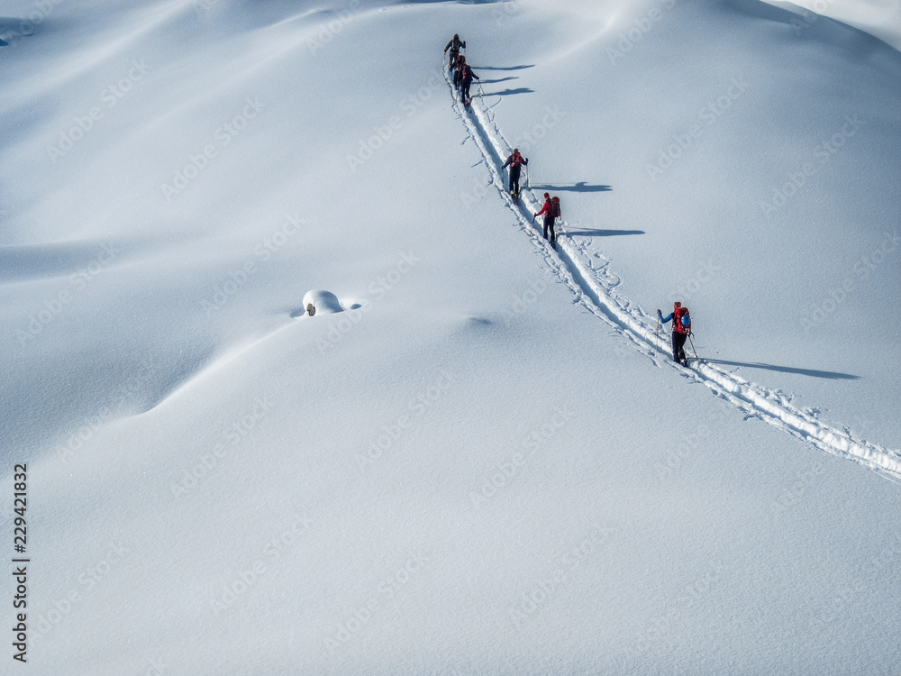 在厚厚的粉雪中滑雪旅行。阿尔卑斯山滑雪运动员在冰川上滑雪旅行。背景图片