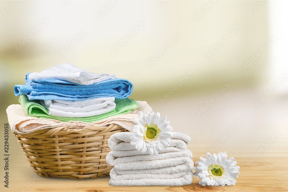 Laundry Basket with colorful towels on background