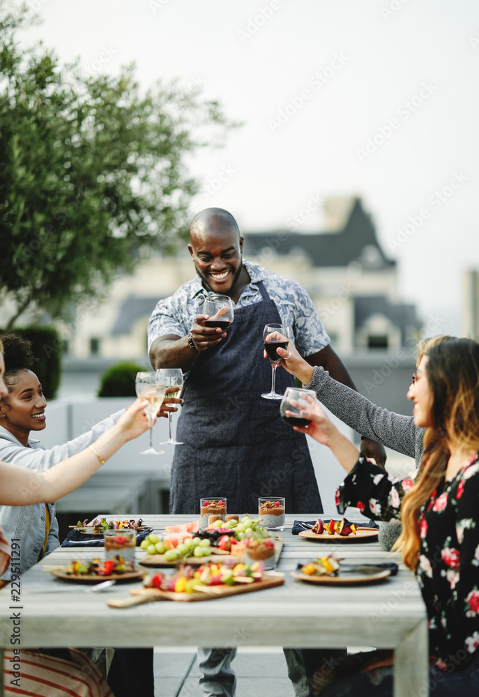 朋友们在夏季聚会上与厨师举杯庆祝