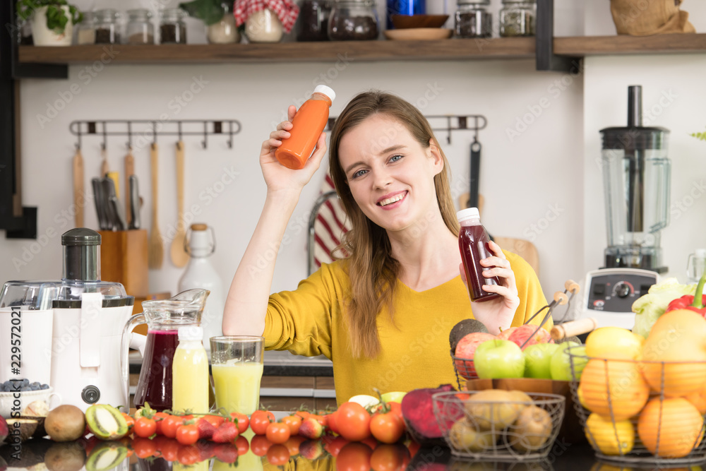 Healthy young woman in a kitchen with fruits and vegetables and juice