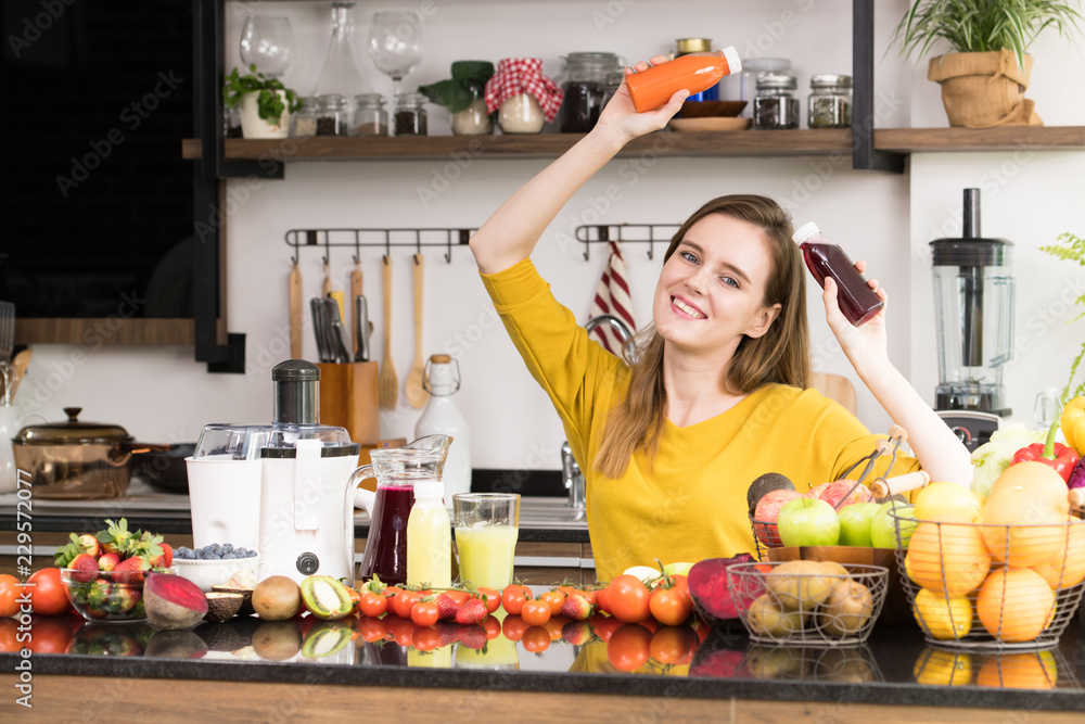 Healthy young woman in a kitchen with fruits and vegetables and juice