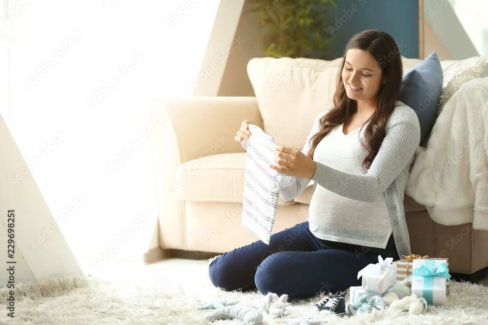 家里有婴儿淋浴礼物的美丽孕妇