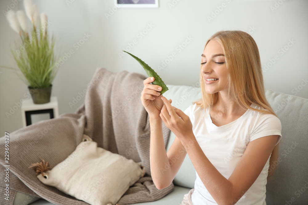 美丽的年轻女子在家中使用芦荟