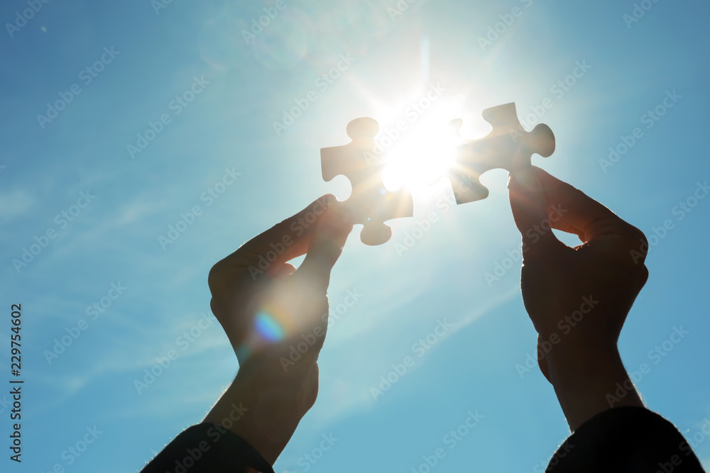 Woman with pieces of puzzle outdoors, closeup