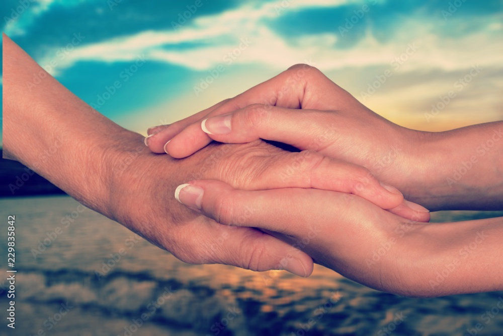 Hands of the old man and a young woman. close up.