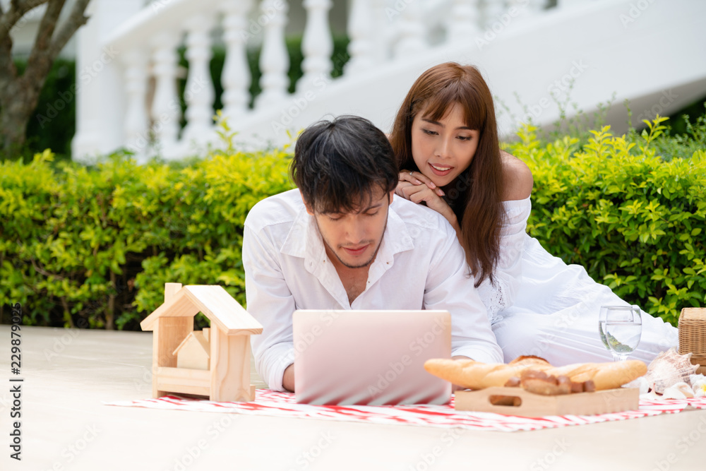 年轻夫妇夏天去公园野餐。