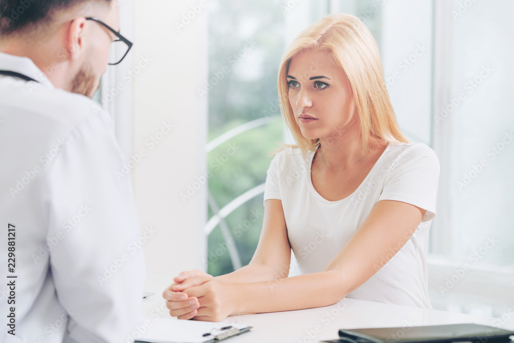 Male Doctor and Female Patient in Hospital Office