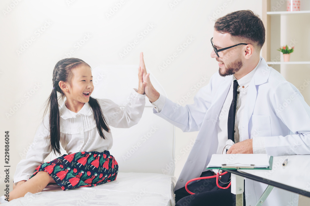 Doctor examining little happy kid in hospital.