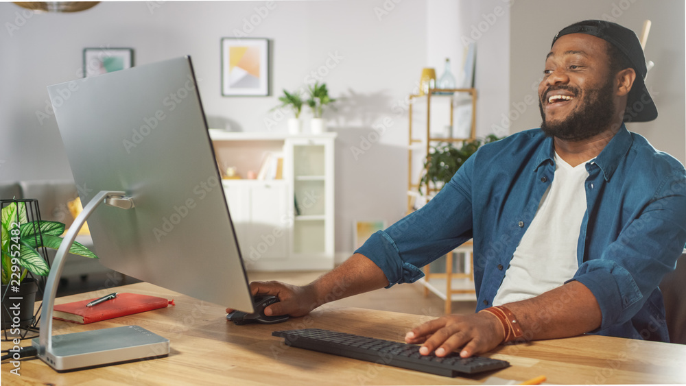 Portrait of the Happy African American Man Laughing at the Video He Watched on His Personal Computer