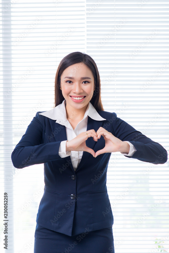 Confident asian businesswoman gesture hands making heart shape