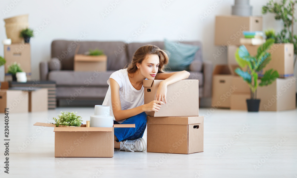 happy   girl with boxes moves to new apartment