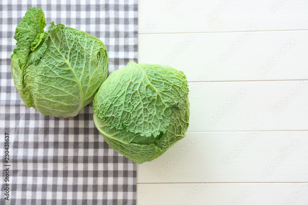 Fresh savoy cabbages on white wooden table