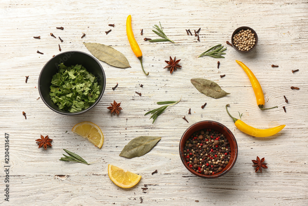 Composition with fresh aromatic herbs and spices on white wooden background