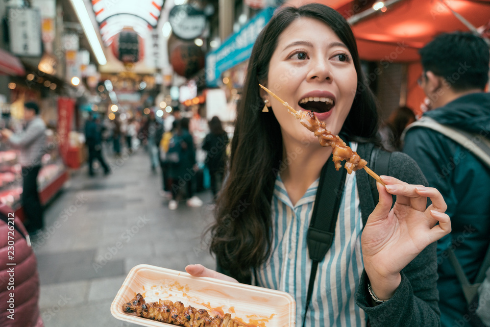 快乐的女人吃美味的烤串