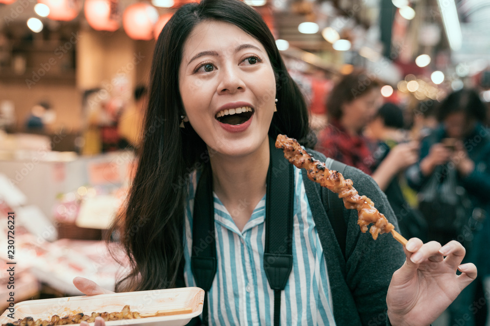 女士游客吃当地特色街头美食