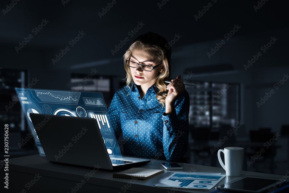 Beautiful blonde working on laptop and infographs out of screen.