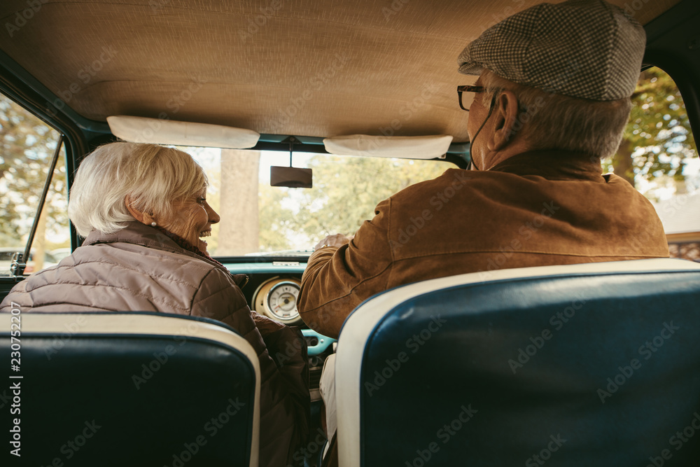 Old couple driving a car on a winter day