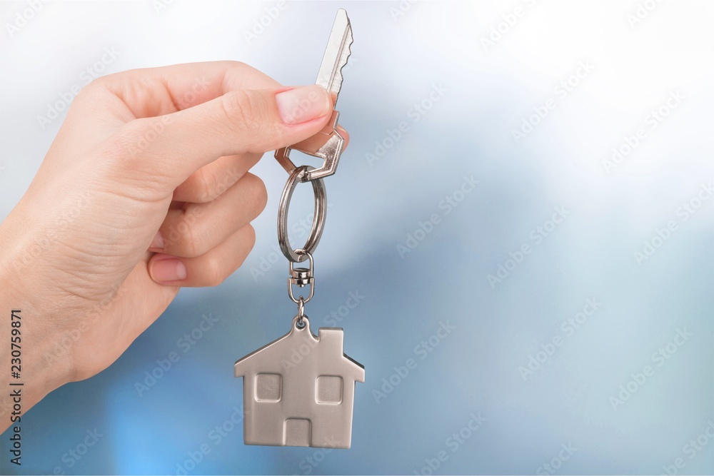 House key in hand on blurred background