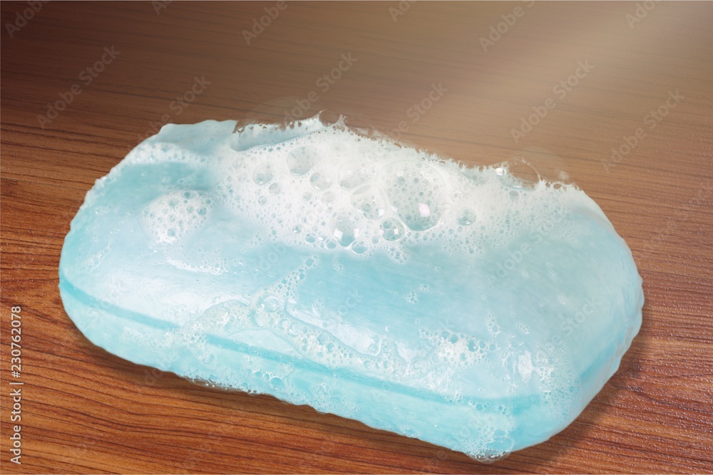 Bar of Blue Soap with Bubbles on white background